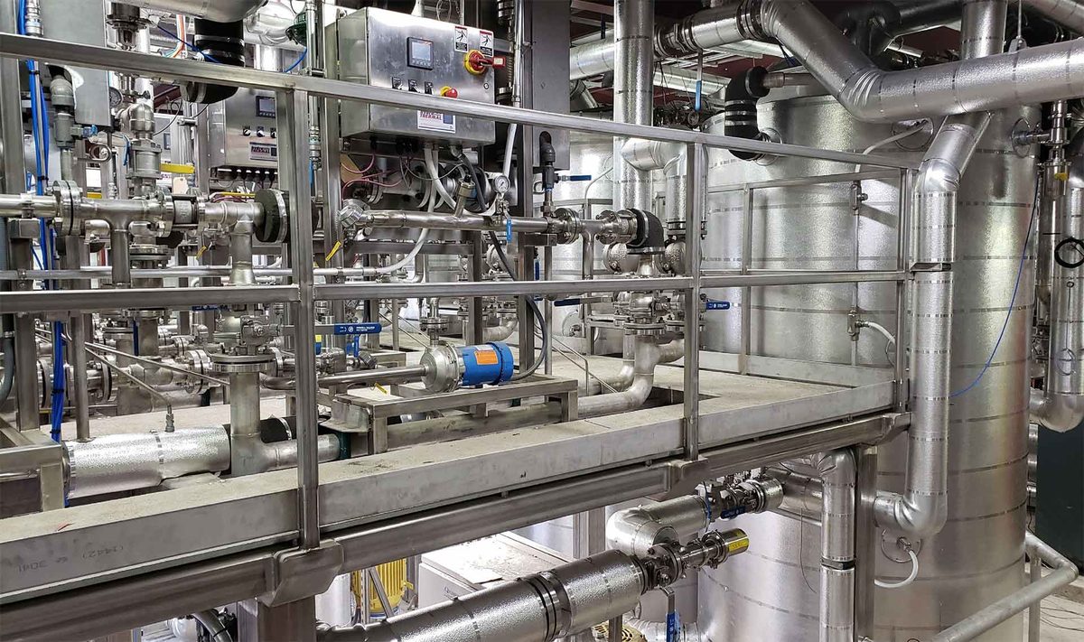 Elevated walkway and insulated process piping in an industrial facility